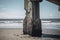 Bridge support pillar on ocean beach. Generate ai