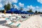 Bridgetown, Barbados - December 12, 2015: sunlounger with people on beach at summer vacation