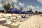 Bridgetown, Barbados - December 12, 2015: sunlounger with people on beach at summer vacation