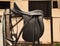 Bridle and professional dressage saddle hanging near stable