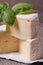 Brie cheese on wooden table with basil macro. vertical