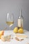 Brie and dorblu cheese with pears, almond, wine glass and bottle on gray