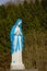 Brigh blue and white sculpture of Lady Mary selective focus with nature background