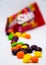 Bright and appetizing candies - skittles. Skittles. Openned pack with skittles in it