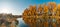 Bright autumn morning landscape. panoramic view from the river bank to lush orange-yellow trees across the river beautifully