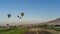 Bright balloons fly over the cultivated fields of the Nile Valley.