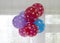 Bright balloons - red, blue and lilac with white polka dots hang in a bunch on the window
