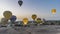 Bright balloons rise in the dawn sky over the desert in Luxor.