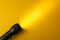 The bright beam of the flashlight illuminates the yellow background