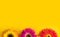 Bright beautiful gerbera flowers on sunny yellow background. Concept of warm summer and early autumn. Place for text