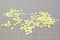 Bright beautiful yellow sparkles scattered on a gray textured background, close up