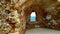 Bright beige stone wall with an arched opening in it. The city of Chania