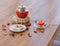 A bright berry tea in a glass teapot next to a transparent glass, a round white plate and dried fruits on a wooden