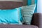 Bright blue designer pillows on a plain brown sofa by the window  interior details closeup