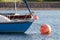 Bright blue sailing boat on a mooring ball