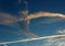 Bright blue skies at dawn, with jet stream trails and wispy clouds