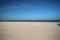 Bright blue sky above North Sea with empty beach due to lockdown by Corona virus