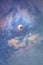 Bright blue sky with clouds and a solar eclipse