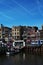 A bright blue sky and houses on the bank of the canal in the center of Amsterdam in the Netherlands