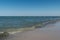 A bright blue sky and the Mediterranean sea with light waves runs over the sandy shore