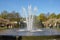 Bright blue sky over water pool fontain in spring time in Keukenhof flower garden. Happy people walking in park