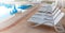 Bright blue swimming pool and empty resting chairs