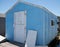 Bright blue and white crab shack with peeling paint and rusty hinges