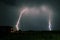 Bright branched lightning bolts hit the earth in the foothills of the Carpathian Mountains in Romania