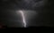 Bright branched lightning strike near an electricity mast from a severe thunderstorm in The Netherlands