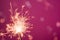 Bright burning sparkling stick on pink background. Generate ai