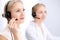 Bright call center office. Two blonde women in a headset