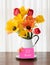 Bright and Cheerful Mothers Day or Birthday Spring Tulip Bouquet in a White Vase on dark wood table and against White Curtain Back