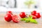 Bright cherry tomatoes on wooden board and white blurred modern kitchen at the background