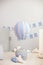 Bright children`s room with a balloon, balloons and textile clouds on a white wall background with holiday flags. Children bedroom