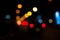 Bright circles from streetlamps on defocused photo of night stre