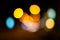 Bright circles from streetlamps on defocused photo of night stre