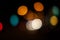 Bright circles from streetlamps on defocused photo of night stre