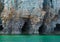 Bright clear aqua green water on Bruce Peninsula with big limestone caves in the cliff