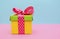 Bright color gift box on pink and blue background.