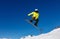 Bright color snowboarder jumps on blue sky backdrop