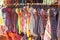 Bright colored children`s dresses or sarafans hang on hangers and are sold in the market of bazaars in India. Showcase with