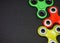 Bright colored fidget finger spinners on dark background