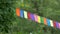 Bright colored flags flutter in wind on sunny warm day. Garland of party flags