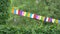 Bright colored flags flutter in wind on sunny warm day. Garland of party flags
