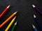 Bright colored pencils on a dark black background. Seven colors of the rainbow. Back to school. Education and creativity. Drawing