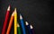 Bright colored pencils on a dark black background. Seven colors of the rainbow. Back to school. Education and creativity. Drawing