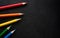 Bright colored pencils on a dark black background. Seven colors of the rainbow. Back to school. Education and creativity. Drawing