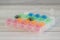 Bright colored plastic bobbins for a sewing machine on a light wooden background close up  in organizer