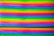 Bright colored vertical stripes of trays stacked in a pile, pink, green, yellow, blue colors. Abstraction, structures,