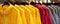 Bright colorful autumn raincoats hanging at a fashion store. Closeup of multi-colored yellow, red, grey, waterproof